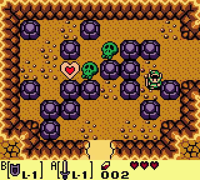 Still frame: a cave room scattered with dark round rocks and two green skull shapes. Link, on the right, pushes a rock to the left.